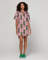 Woman wearing a floral dress with a plain background