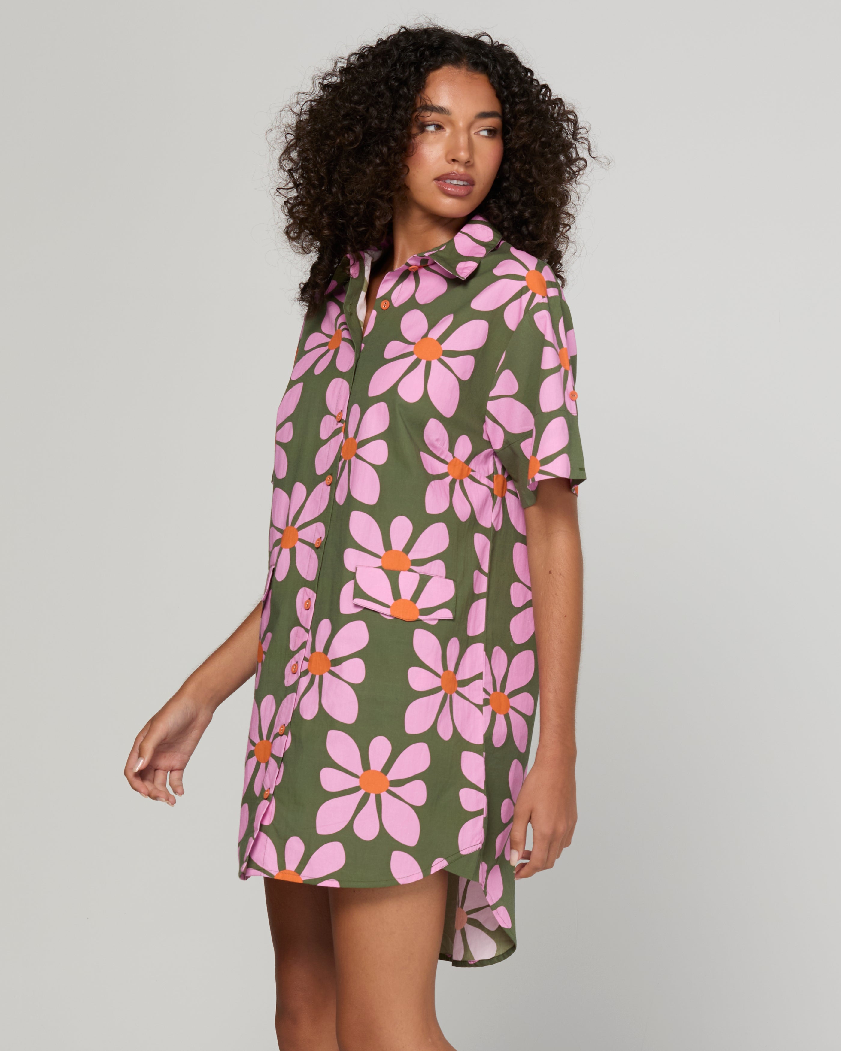 Woman wearing a floral dress with pink flowers on a green background