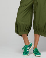 Green guru pants with  green sneakers on a plain background