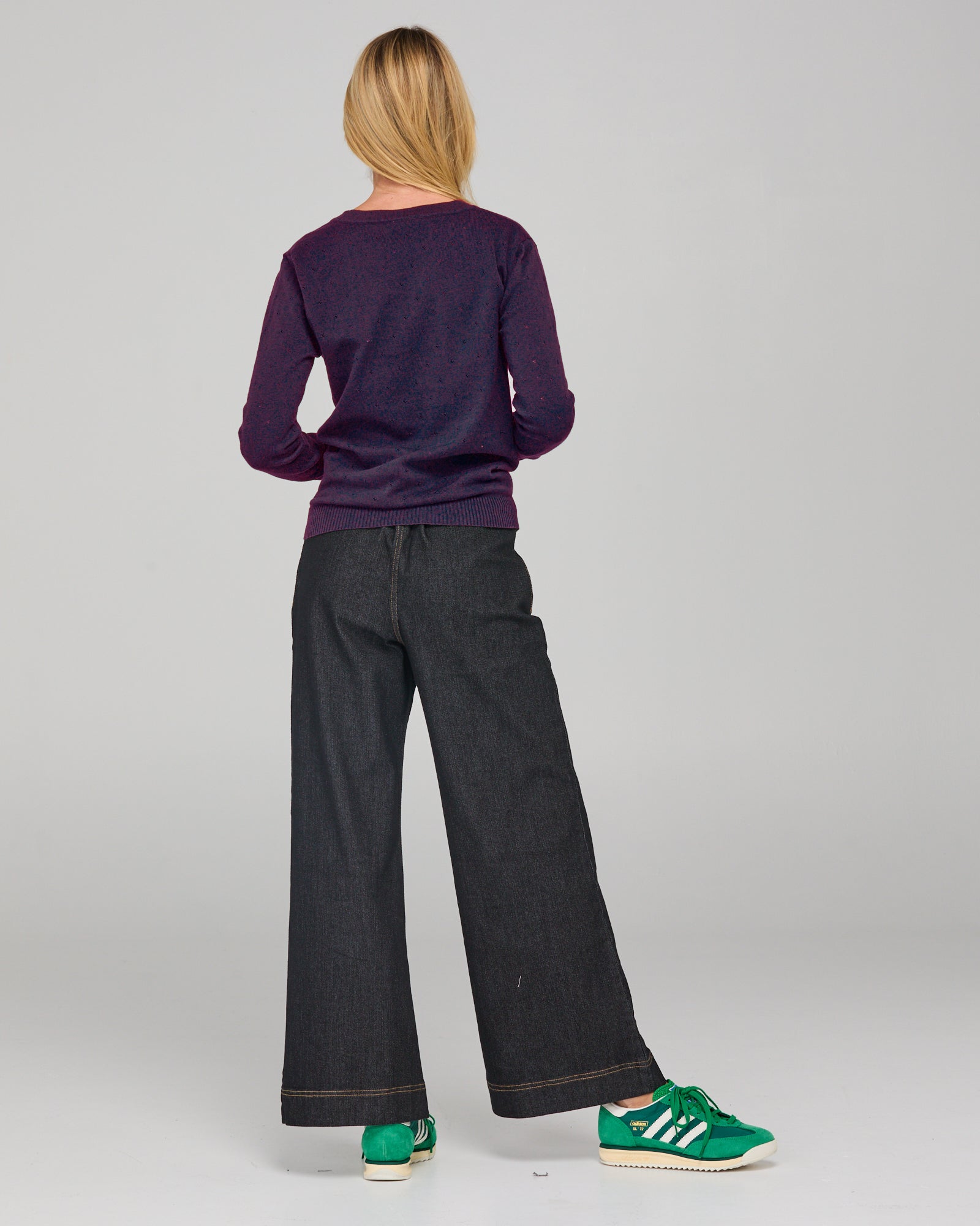 A woman modeling a dark purple v-neck cardigan sweater